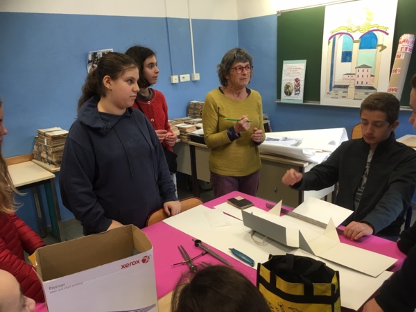 Madame Arnold explique aux élèves la  fabrication les boites qui serviront à l'archivage des livres